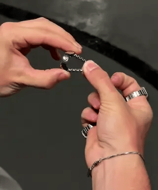 montre-bague argentée avec anneau réglable, gros plan sur le mécanisme d'ajustement
