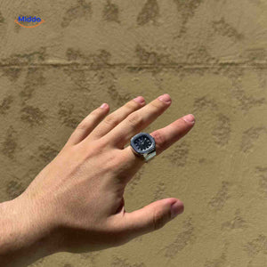 montre-bague argent avec cadran noir portée sur une main, accessoire élégant