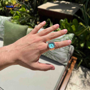 montre-bague rose avec cadran vert menthe portée sur une main, style coloré