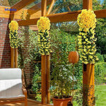 orchidées artificielles jaunes fixées devant une haie de jardin, couleur vive toute saison
