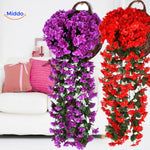 orchidées artificielles violettes et rouges dans un panier suspendu au mur d'un salon, ambiance chaleureuse