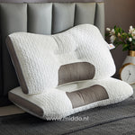 oreiller soutien nuque ergonomique posé sur un lit fait dans une chambre apaisante