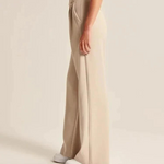 pantalon large femme beige vu de côté, porté avec des chaussures blanches