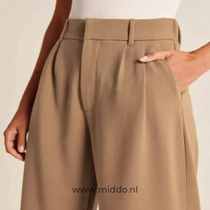 gros plan sur le pantalon large femme brun, main glissée dans la poche latérale
