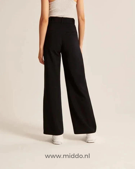 pantalon large femme noir en situation avec baskets blanches, silhouette fluide