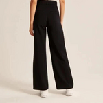 pantalon large femme noir en situation avec baskets blanches, silhouette fluide