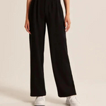 pantalon large femme noir porté avec des baskets blanches, look casual