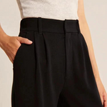 gros plan sur le pantalon large femme noir, main glissée dans la poche latérale