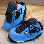 pantoufles sneakers bleues avec accents noirs et rouges, posées sur une surface en osier