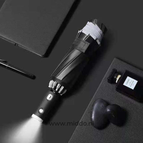 parapluie réfléchissant avec lampe torche intégrée dans la poignée, entouré d'objets du quotidien