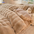 couverture et coussins en peluche beige disposés harmonieusement sur un lit