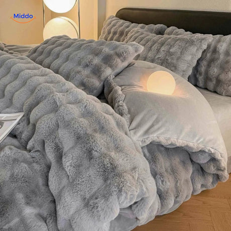 parure de lit en peluche grise aux tons clairs présentée sur un lit bien ordonné