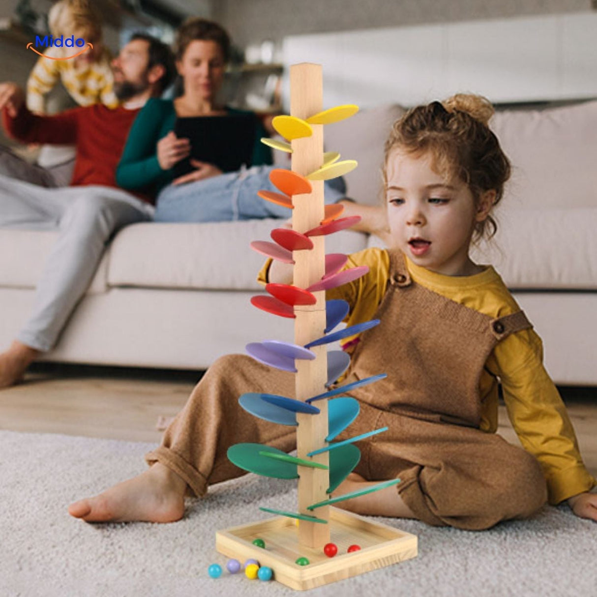 moment en famille avec des enfants qui jouent ensemble avec la piste à billes arbre en bois