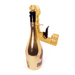pistolet à boissons doré fixé sur une bouteille de champagne, vue de profil