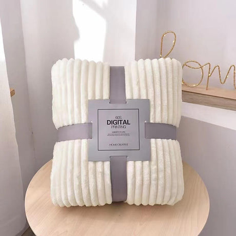 plaid en velours polaire blanc immaculé plié et emballé avec un bandeau gris, idée cadeau