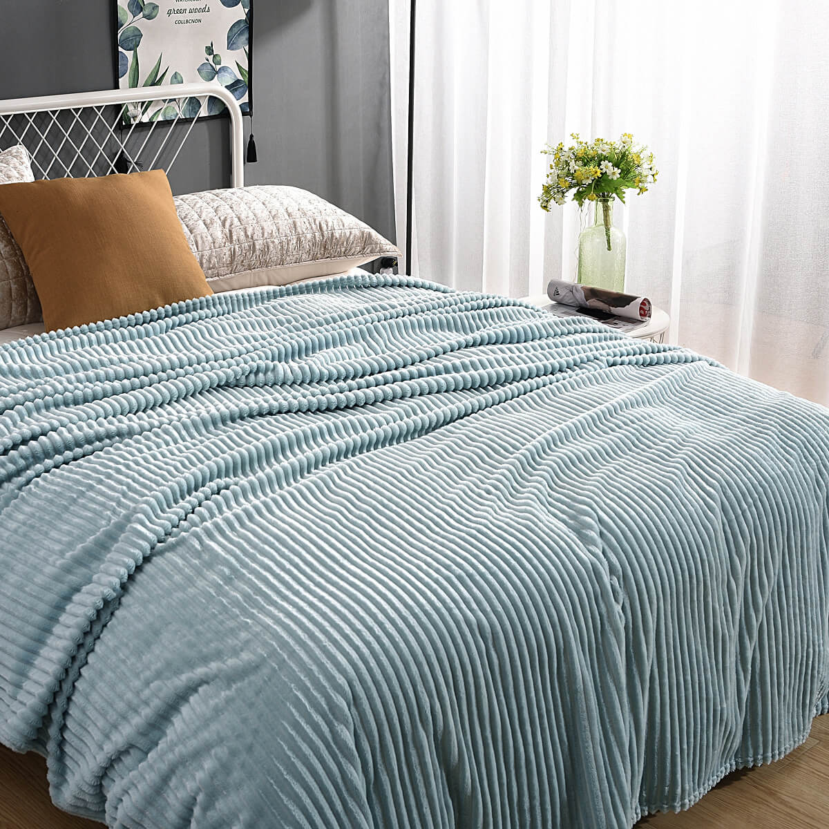 plaid en velours polaire bleu ciel sur un lit soigneusement fait avec coussin assorti
