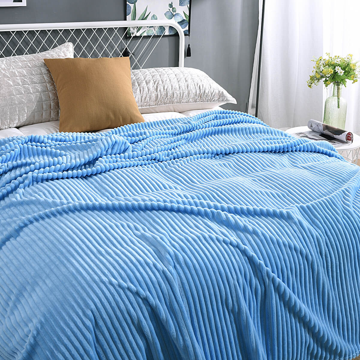 plaid en velours polaire bleu clair doux sur un lit bien préparé, coloris reposant