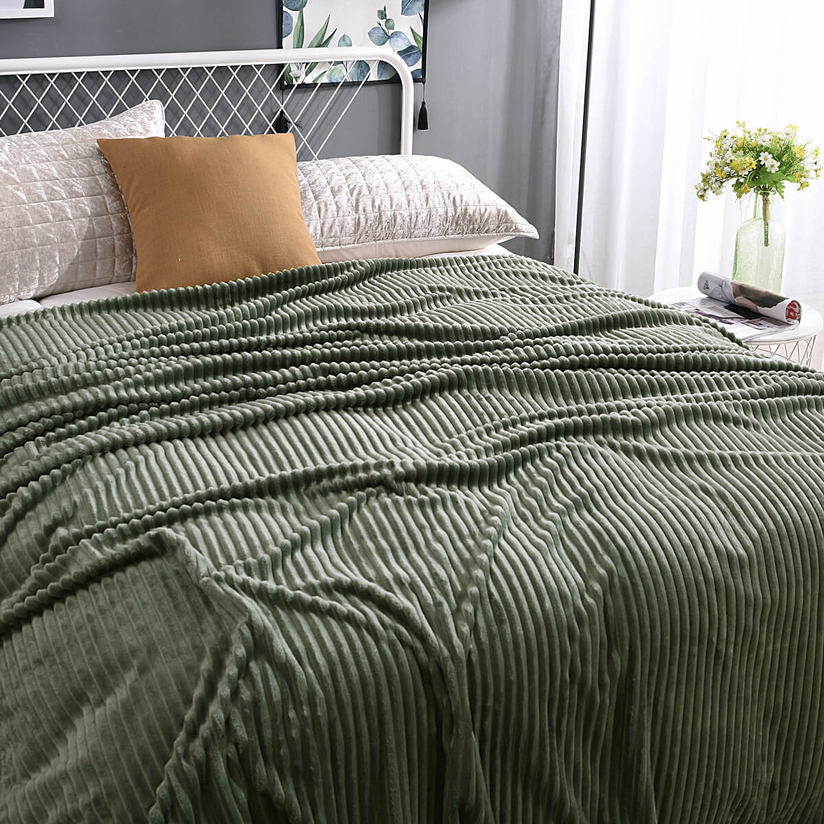 plaid en velours polaire vert apaisant sur un lit fait avec soin, toucher soyeux
