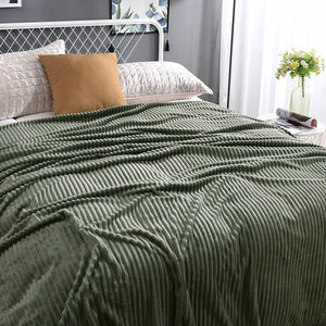 plaid en velours polaire vert apaisant sur un lit fait avec soin, toucher soyeux