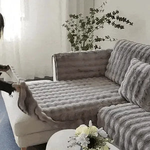 femme installant une housse de canapé grise et moelleuse sur son canapé