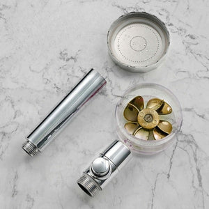 pommeau de douche puissant entièrement démonté et ses composants présentés sur fond marbre