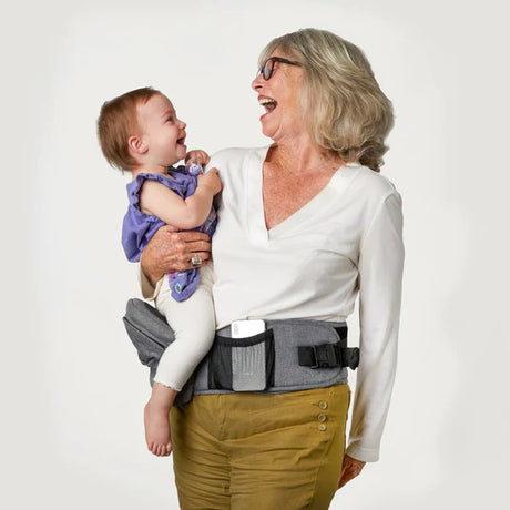 porte-bébé ergonomique porté par une grand-mère souriante avec son bébé dans les bras
