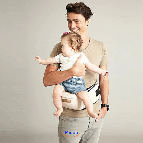 père qui porte son bébé avec le siège de portage ergonomique en coloris beige
