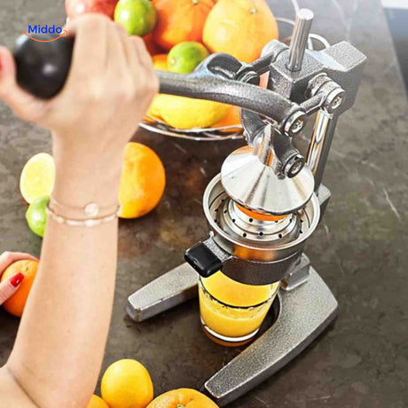 presse-agrumes manuelle en fonte avec un verre de jus fraîchement pressé
