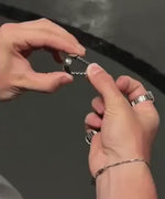 montre-bague argentée avec anneau réglable, gros plan sur le mécanisme d'ajustement