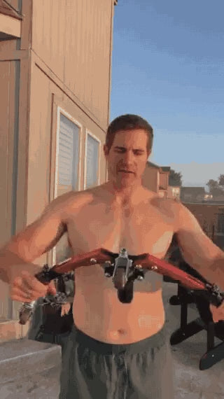 homme utilisant l'appareil d'entraînement pour les bras lors d'un workout en extérieur