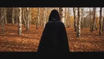 cape velours noire à capuche en forêt, atmosphère halloween mystérieuse