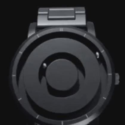 montre magnétique noire avec aiguilles qui se positionnent par attraction, animation en mouvement