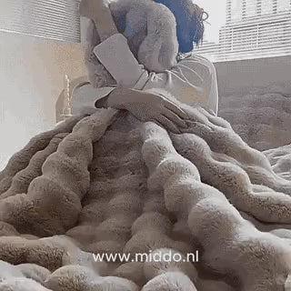 femme lovée dans une couverture toscane fluffy, atmosphère chaleureuse et cocooning