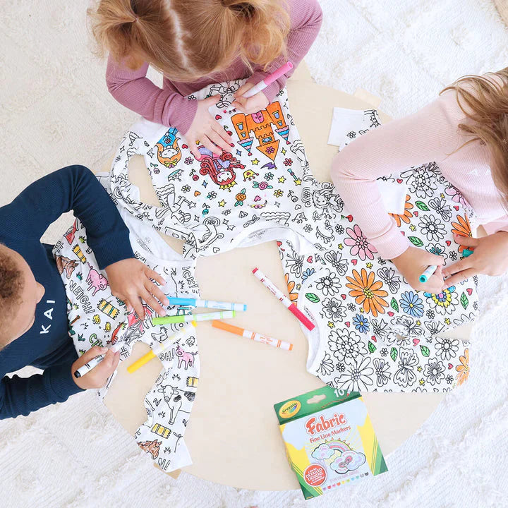 plusieurs enfants assis à une table en train de colorier leurs pyjamas à colorier ensemble