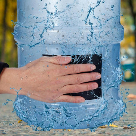main appliquant le ruban étanche sur un réservoir d'eau qui fuit pour le sceller