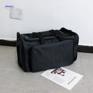 sac de voyage noir avec texte gris clair discret sur la face avant