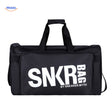 sac de sport et voyage noir tenu en main, texte blanc visible sur la face avant