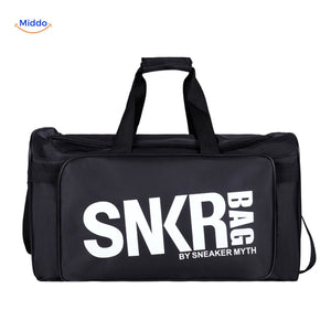 sac de sport et voyage noir tenu en main, texte blanc visible sur la face avant