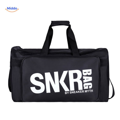 sac de sport et voyage noir tenu en main, texte blanc visible sur la face avant