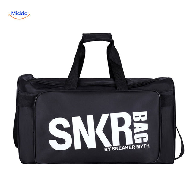sac de sport et voyage noir tenu en main, texte blanc visible sur la face avant
