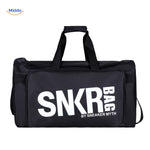 sac de sport et voyage noir tenu en main, texte blanc visible sur la face avant