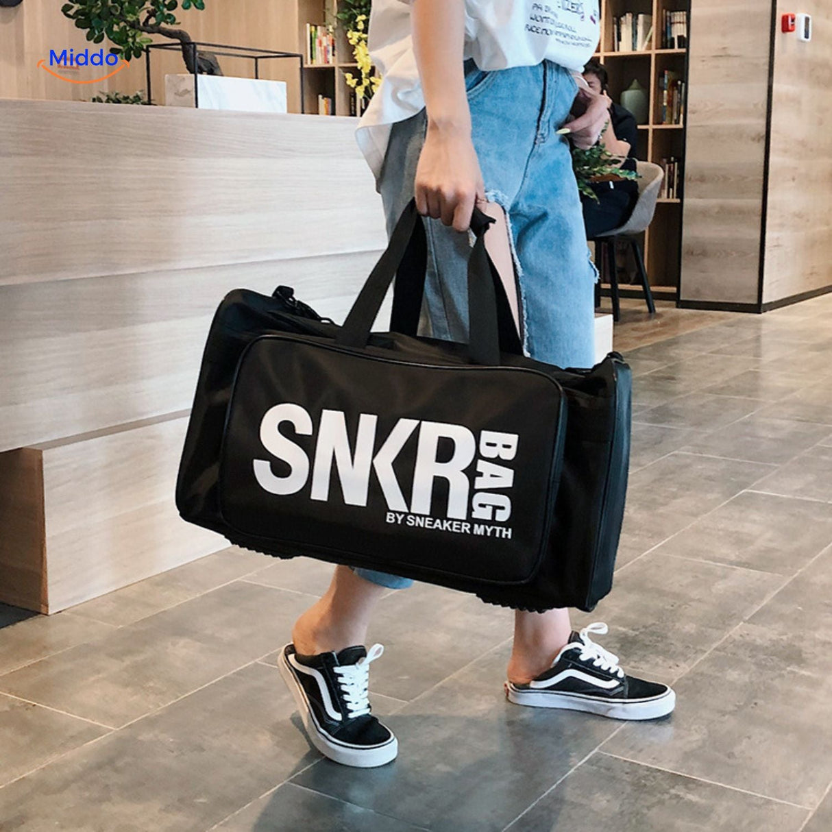 personne avec des gants tenant le sac de sport noir, ideal pour les sportifs