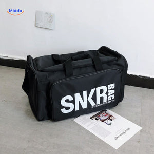 sac de voyage noir avec grand texte blanc en evidence sur la face principale