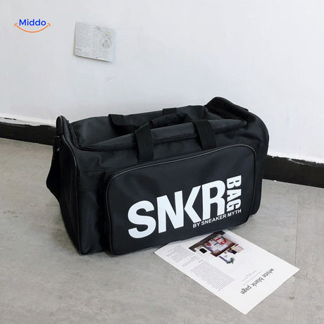 sac de voyage noir avec grand texte blanc en evidence sur la face principale