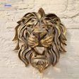 sculpture tête de lion en résine dorée fixée sur un mur, décoration murale majestueuse