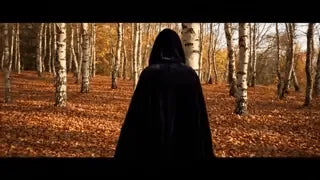 cape velours noire à capuche en forêt, atmosphère halloween mystérieuse