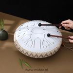 mains jouant un steel tongue drum blanc 33 cm avec des mailloches