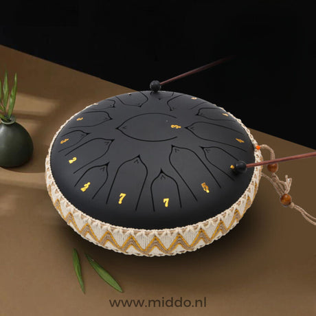 mains jouant un steel tongue drum noir 33 cm avec des mailloches