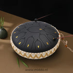 mains jouant un steel tongue drum noir 33 cm avec des mailloches
