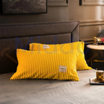 taies d'oreiller en velours polaire jaune sur lit gris clair ambiance cocooning